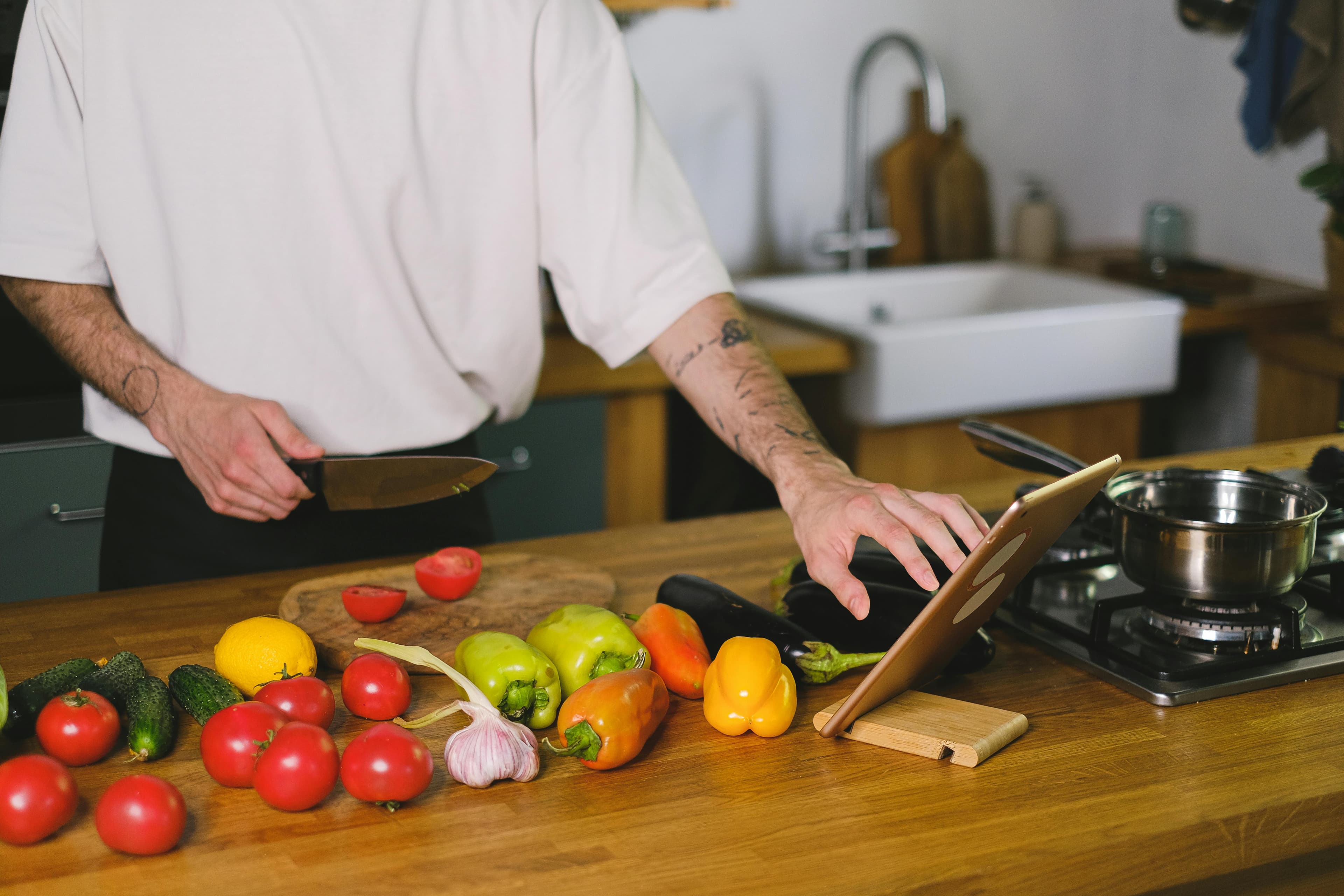 Cook following steps on a tablet while preparing vegetables.